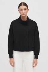Woman in a jacket standing with her hands at her sides