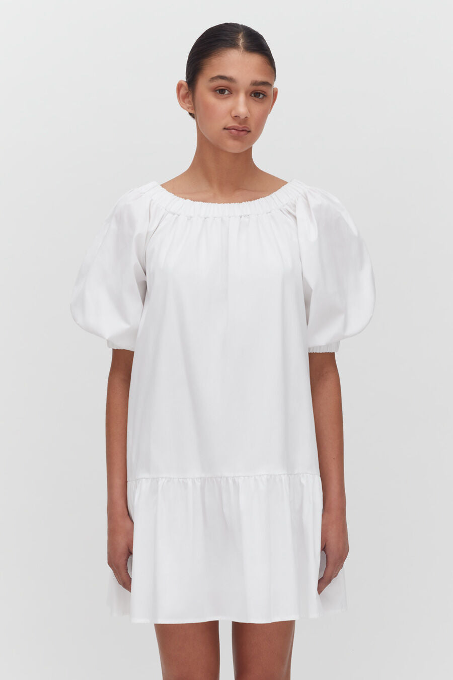 Woman standing in a simple puff-sleeved dress