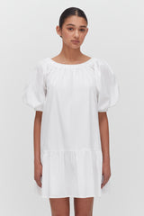 Woman standing in a simple puff-sleeved dress