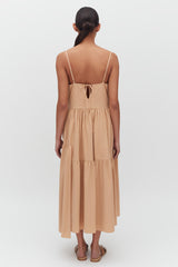 Woman from behind wearing a sleeveless, knee-length dress standing upright.