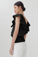 Woman in a layered top looking over her shoulder