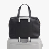 Bag on top of a suitcase, handles up