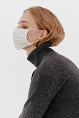 Woman wearing a mask in profile view.