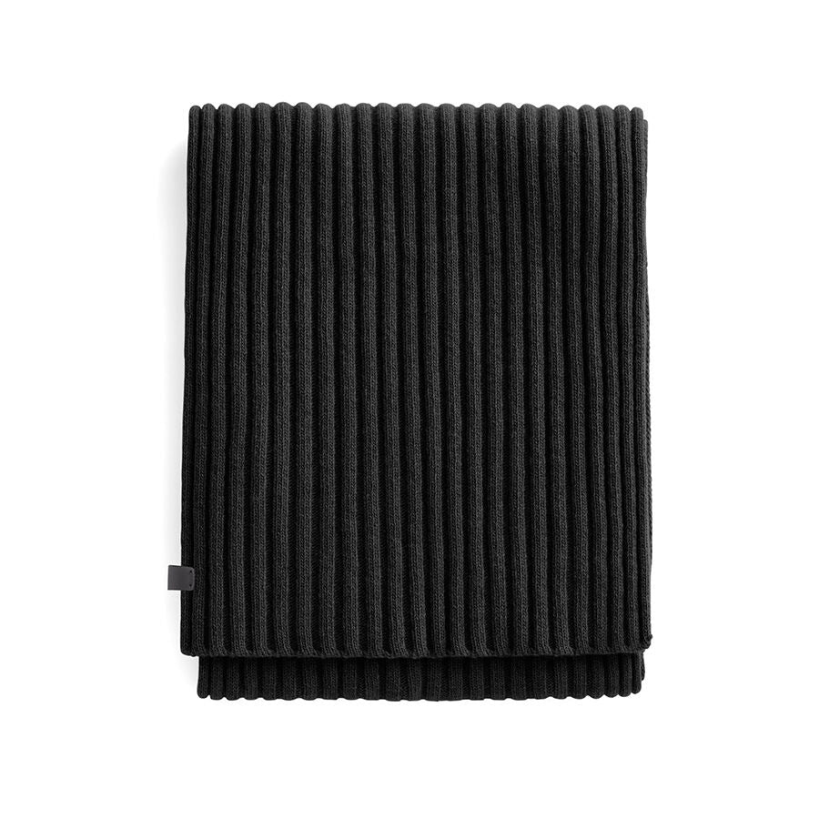 A folded ribbed scarf with a small tag on one side.